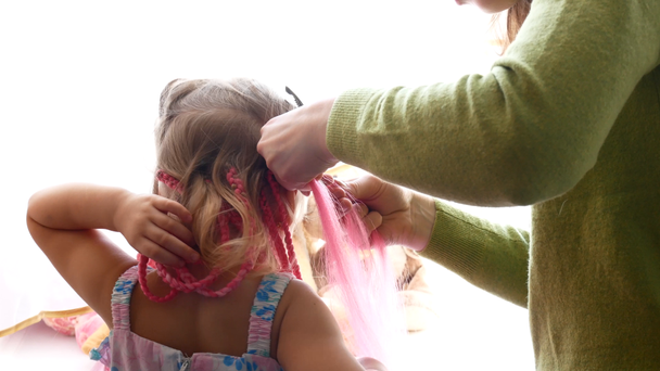 Дівчина плетений з кольоровими африканських косами - Кадри, відео