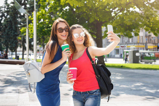 Onnellisia tyttöjä älypuhelimen kanssa ulkona puistossa
 - Valokuva, kuva