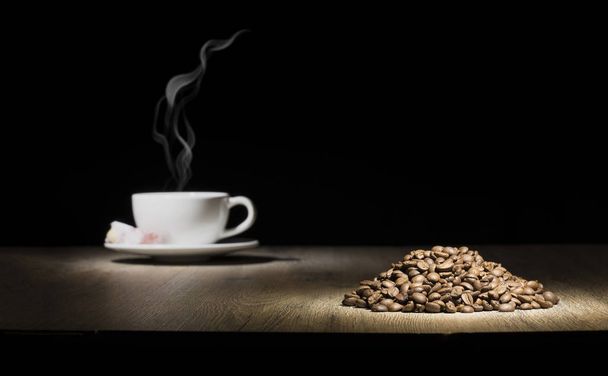 steamed coffee cup on the wood table with coffee beans stack - Фото, зображення