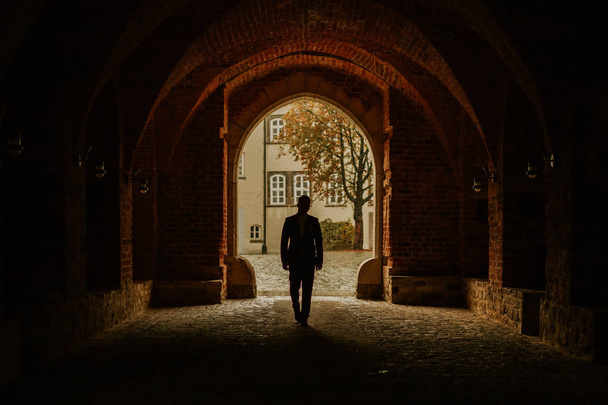 mies kävellä tunnelissa yksin auringonlaskun siluetti
. - Valokuva, kuva