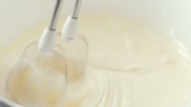 Close-up mixer whip eggs to a froth in white bowl. Cooking apple pie. - Filmati, video