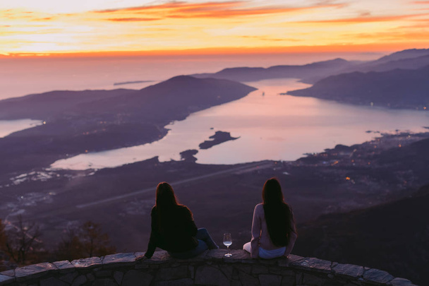 girls travel and drink wine  at sunset in mountains - Photo, Image