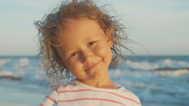 Retrato facial de una hermosa niña de pie en la playa
 - Imágenes, Vídeo