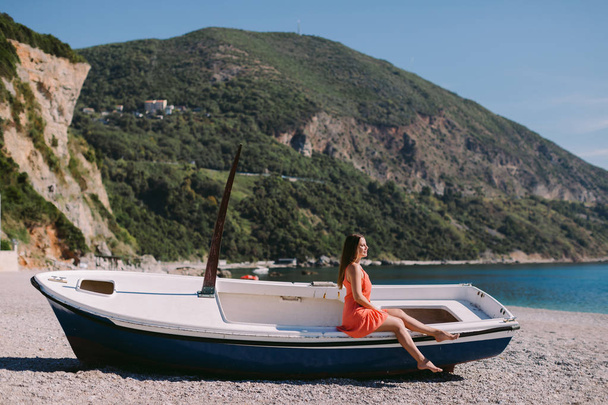 žena sedí na pláži v lodi. dovolená. Cestovní destinace Černá Hora. - Fotografie, Obrázek