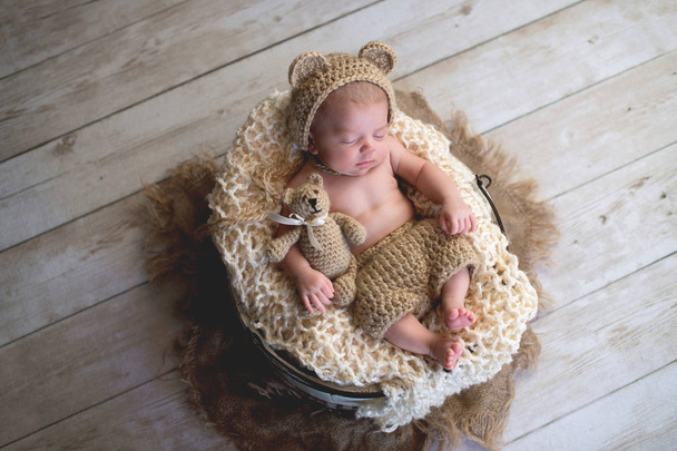 Bebé con sombrero de oso y juguete de oso de peluche
 - Foto, imagen