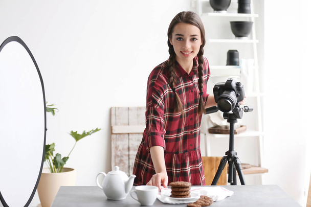 Young woman with professional camera preparing food composition in photo studio - Valokuva, kuva