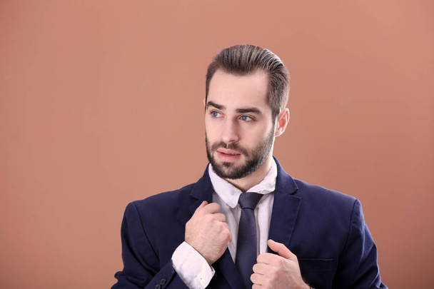 Portrait of young businessman with beautiful hair on color background - Foto, Imagem