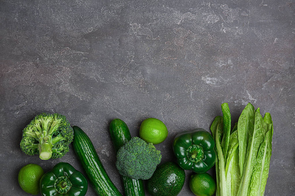 Different green vegetables and fruits on dark background, top view - Foto, Imagem