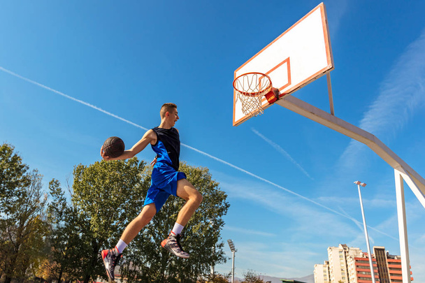 Young Basketball street player making slam dunk - Foto, Bild