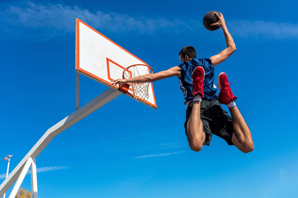 Young Basketball street player making slam dunk - Foto, afbeelding