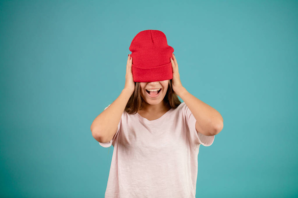 cheerful young female in casual clothing with stuck red cap to her straight hair - Φωτογραφία, εικόνα