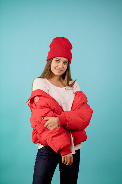 Young woman wearing red pullover jacket on isolated blue background - Фото, зображення