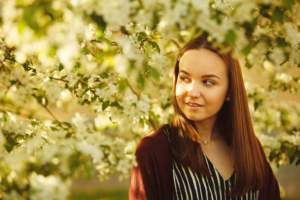 young woman with clean skin near a blooming apple tree. portrait of girl in spring park. - Foto, Bild