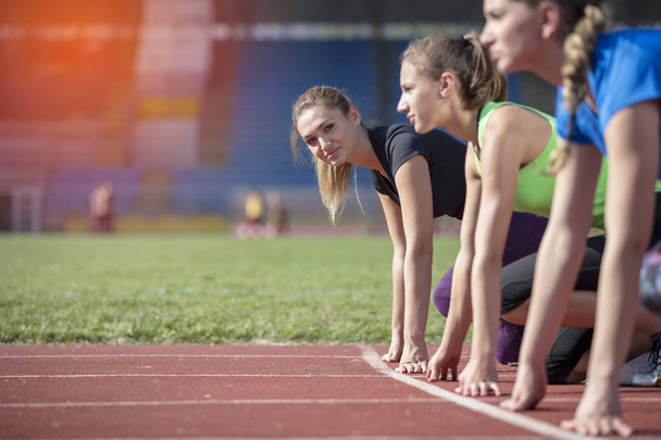 Женщины готовы к гонке на легкоатлетическом поле
 - Фото, изображение