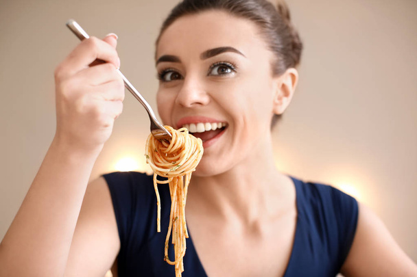 Jovem mulher comendo massa saborosa no restaurante
 - Foto, Imagem