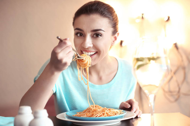 Young woman eating tasty pasta in cafe - Фото, зображення