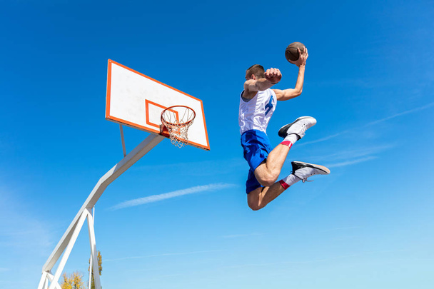 Молодой баскетболист с улицы бросает мяч в лоб
 - Фото, изображение