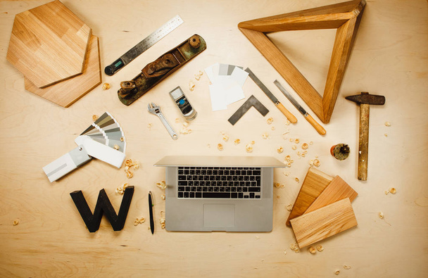 Tesařské práce nástroje a laptop na pozadí s dřevěnými řízky. - Fotografie, Obrázek