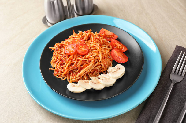 Plate of delicious pasta with tomato sauce on table - Fotó, kép