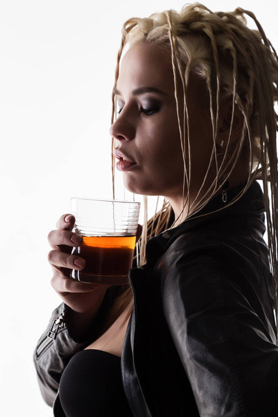 sexy woman with dreadlocks holding a glass of whiskey - Fotó, kép