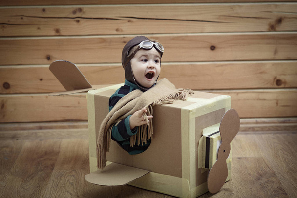 child in a cardboard box playing - Фото, изображение