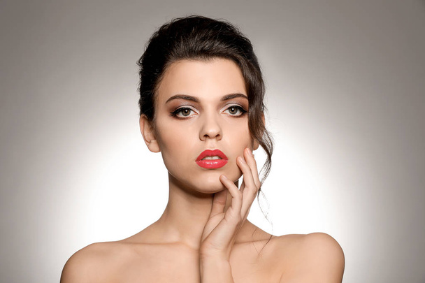 Portret van een jonge vrouw met mooie professionele make-up op lichte achtergrond - Foto, afbeelding
