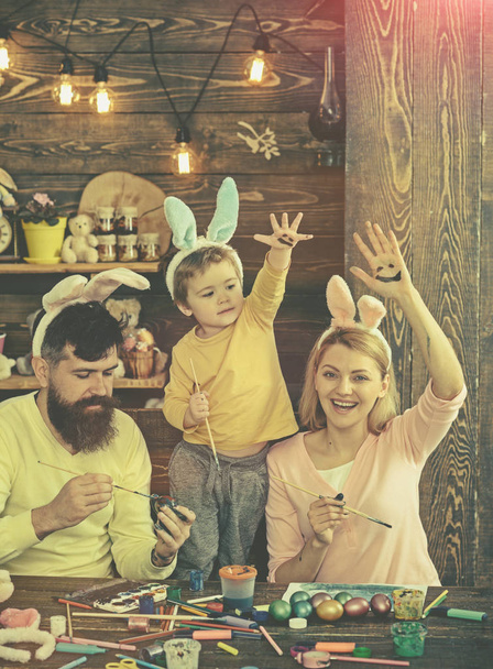 Father, mother and her child enjoy painting Easter eggs. - Foto, Bild