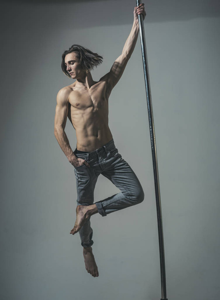 Guy makes figure on pole, fly in air. Work out. - Foto, imagen
