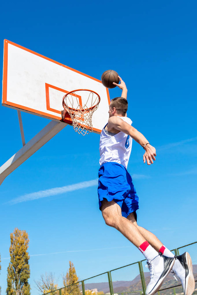 Young Basketball street player making slam dunk - Foto, immagini