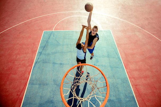 High angle view of basketball player dunking basketball in hoop - Fotoğraf, Görsel