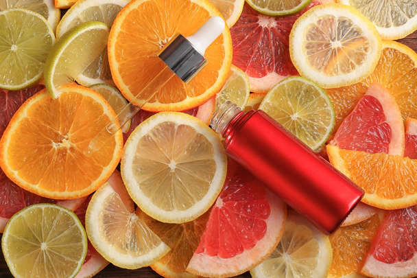 Bottle of essential oil on citrus slices - Photo, Image