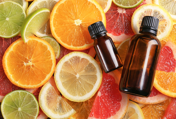Bottles of essential oil on citrus slices - Fotografie, Obrázek