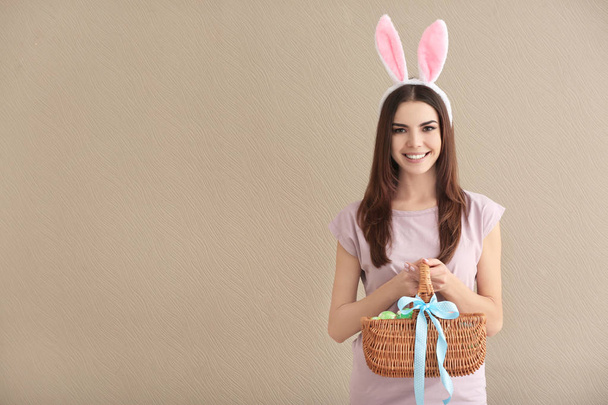 Belle jeune femme avec des œufs de Pâques et des oreilles de lapin sur fond de couleur
 - Photo, image