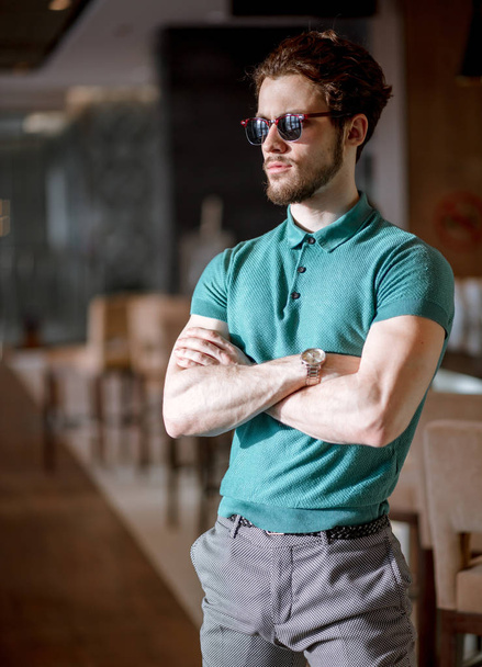 side view portrait of bodyguard with crossed arms at the cafe. - Foto, Imagen