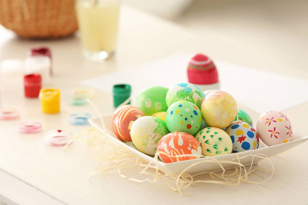 Assiette avec des œufs de Pâques peints colorés sur la table
 - Photo, image