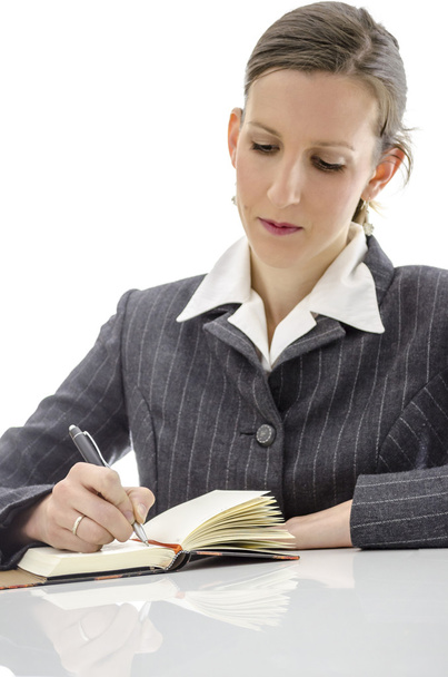 Businesswoman writing in her notepad - Фото, зображення