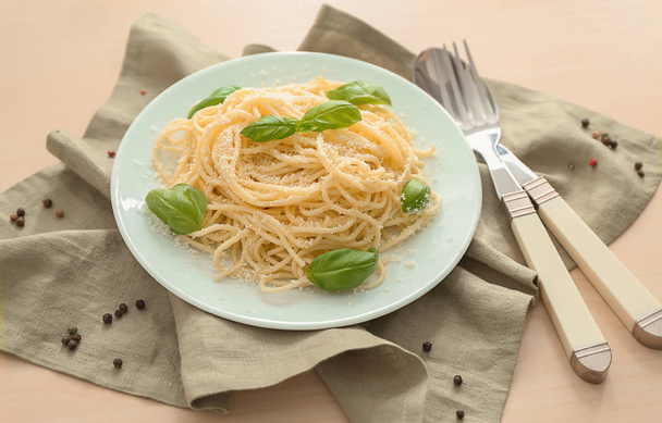 Plate with spaghetti and basil on table. Delicious pasta recipes - Fotó, kép
