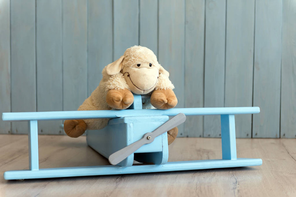 Деревянная модель ретро-самолета и овечья игрушка поверх ретро-винтажного бро
 - Фото, изображение
