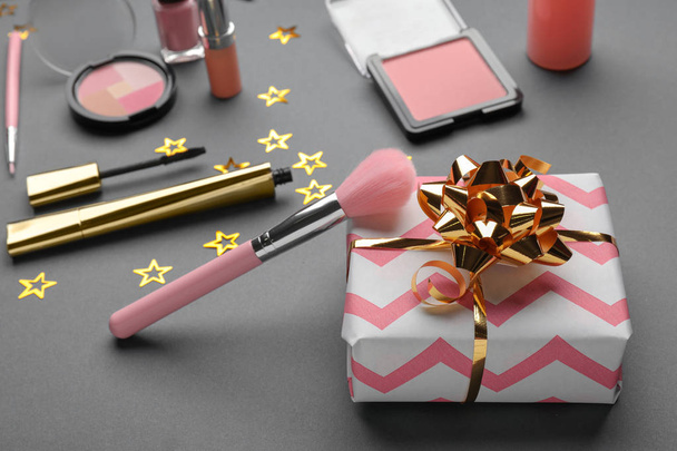 Caja de regalo y set de cosméticos decorativos sobre fondo gris
 - Foto, Imagen