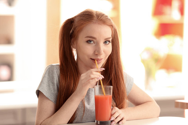 Красивая молодая женщина пьет цитрусовый сок на кухне
 - Фото, изображение