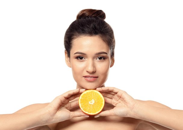 Beautiful young woman with citrus fruit on white background - 写真・画像