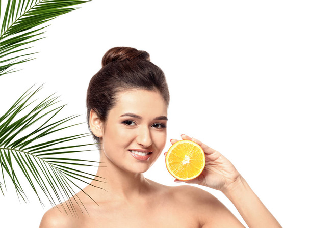Krásná mladá žena s citrusových plodů a palmového listí na bílém pozadí - Fotografie, Obrázek