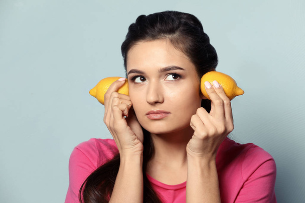 Funny young woman with citrus fruit on color background - Fotografie, Obrázek