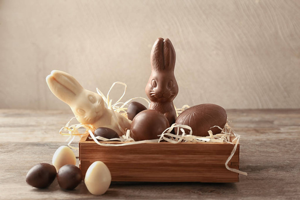 Cioccolato Coniglietti pasquali e uova in gabbia in tavola
 - Foto, immagini