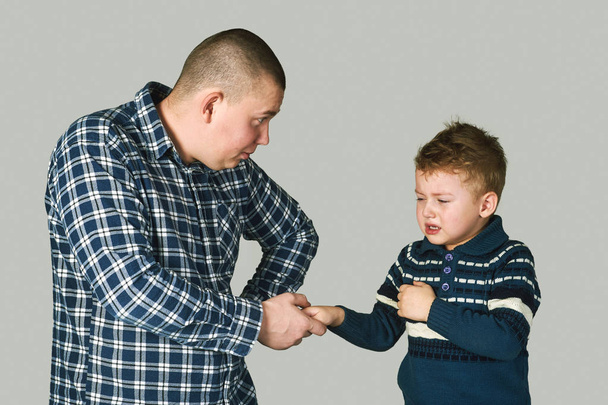 El padre sostiene la mano de un niño llorando
 - Foto, imagen