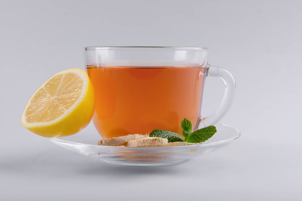 Cup of delicious tea with mint, ginger and lemon on grey background - Fotoğraf, Görsel