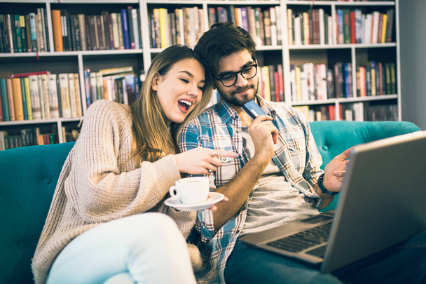 Couple achetant en ligne avec carte de crédit et ordinateur portable dans un café
 - Photo, image
