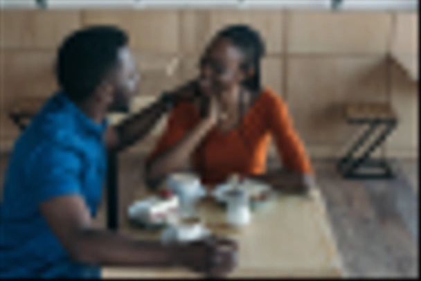 szczęśliwy african american para siedzi przy stole z filiżanki kawy i desery w kawiarni - Zdjęcie, obraz