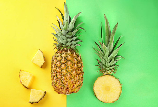 Hele en gesneden verse ananas op kleur achtergrond - Foto, afbeelding