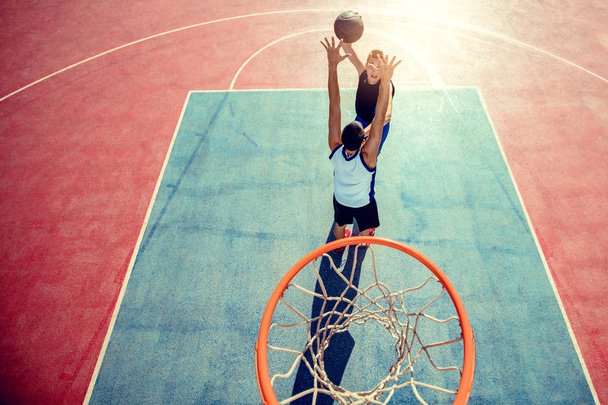 High angle view of basketball player dunking basketball in hoop - Fotoğraf, Görsel